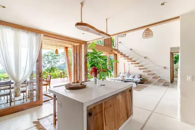 an open kitchen with a staircase and a living room at 3 Rooms Salt pool Star Link 4 min To Santa in Cóbano