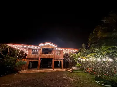 a house lit up at night with christmas lights at Mountain Retreat Refugio de Aves in Turrialba