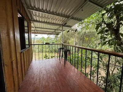 a porch of a house with a table on it at Mountain Retreat Refugio de Aves in Turrialba