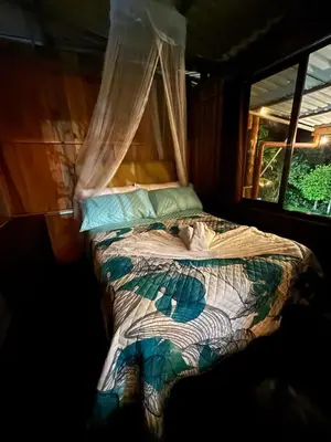 a bed in a room with a window at Mountain Retreat Refugio de Aves in Turrialba