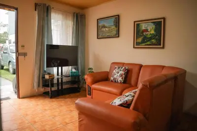 a living room with a couch and a television at 5-minute walk downtown apartment in Fortuna