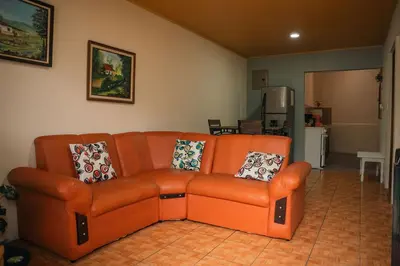 an orange couch sitting in a living room at 5-minute walk downtown apartment in Fortuna