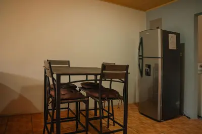a table and four chairs next to a refrigerator at 5-minute walk downtown apartment in Fortuna