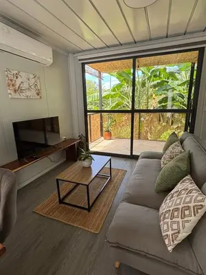 a living room with a couch and a table at Salty studio apt Santa Teresa center in Santa Teresa Beach