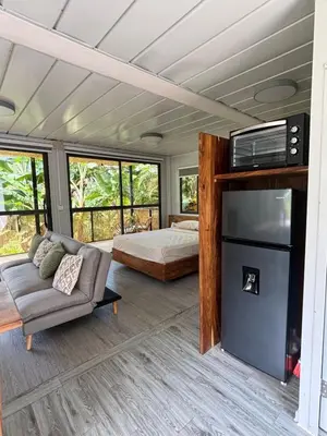 a living room with a bed and a couch at Salty studio apt Santa Teresa center in Santa Teresa Beach