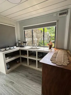 a kitchen with a sink and a large window at Salty studio apt Santa Teresa center in Santa Teresa Beach