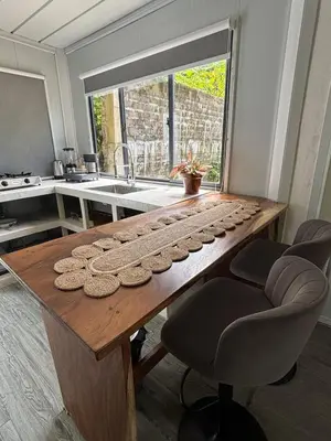 a kitchen with a wooden table with a keyboard at Salty studio apt Santa Teresa center in Santa Teresa Beach