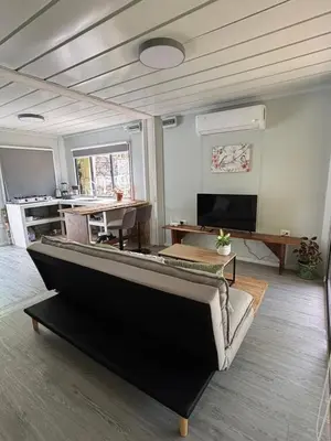 a living room with a couch and a table at Salty studio apt Santa Teresa center in Santa Teresa Beach