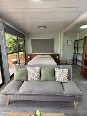 a living room with a couch and a bed at Salty studio apt Santa Teresa center in Santa Teresa Beach