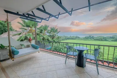 a balcony with a couch and a table and chairs at Villa Marala in Esterillos