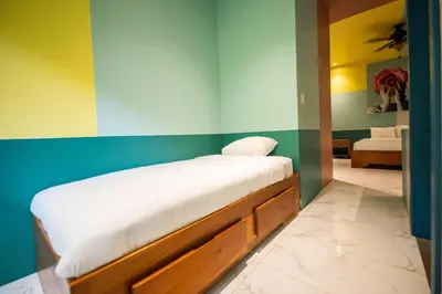 a bedroom with a bed with white sheets on it at Villa Marala in Esterillos
