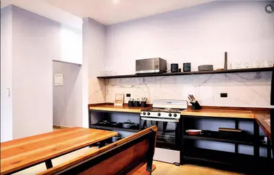 a kitchen with a table and a stove in it at El Castillo Casa Azul in Cuajiniquil