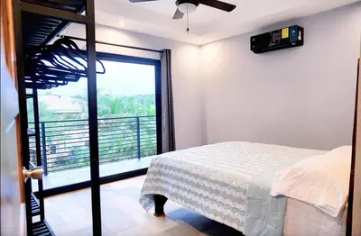 a bedroom with a bed and a large window at El Castillo Casa Azul in Cuajiniquil