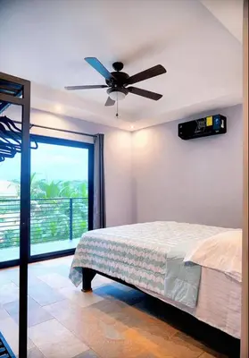 a bedroom with a bed and a ceiling fan at El Castillo Casa Azul in Cuajiniquil