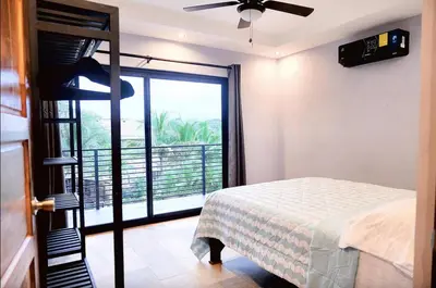 a bedroom with a bed and a large window at El Castillo Casa Azul in Cuajiniquil