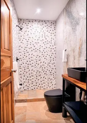 a bathroom with a black toilet and a sink at El Castillo Casa Azul in Cuajiniquil