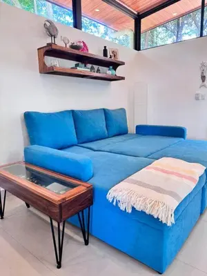 a blue couch in a living room with a table at Mermaid House in Matapalo