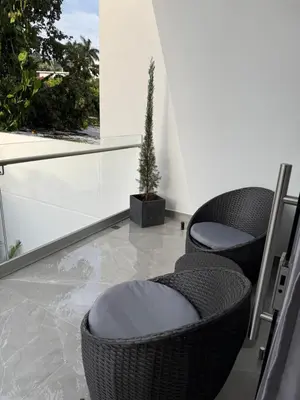 a balcony with two chairs and a potted plant at Penthouse 333 in Escazu