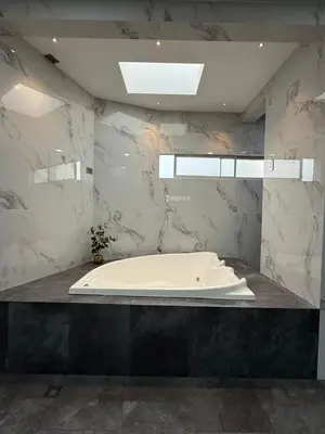 a bath tub in a bathroom with marble walls at Penthouse 333 in Escazu