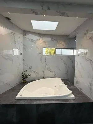 a white bath tub in a bathroom with marble walls at Penthouse 333 in Escazu