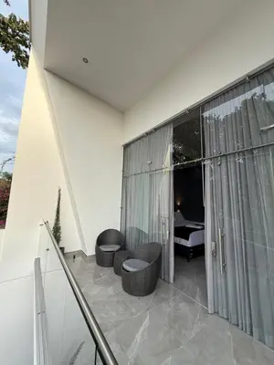 a balcony with two chairs and a room with a bed at Penthouse 333 in Escazu