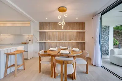 a kitchen and dining room with a wooden table and chairs at Seaside Hideaway Walk to Playa Flamingo Marina in Playa Flamingo