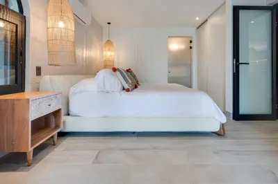 a bedroom with a large white bed and a dresser at Seaside Hideaway Walk to Playa Flamingo Marina in Playa Flamingo