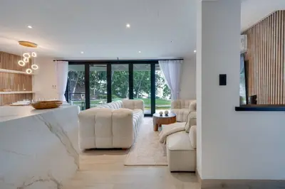 a living room with white furniture and large windows at Seaside Hideaway Walk to Playa Flamingo Marina in Playa Flamingo