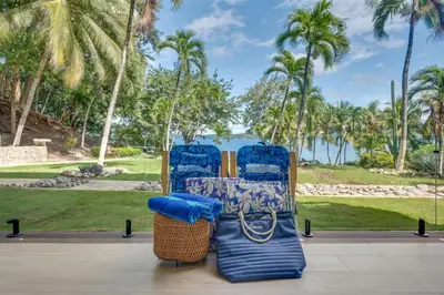 a group of chairs sitting on a patio with palm trees at Seaside Hideaway Walk to Playa Flamingo Marina in Playa Flamingo