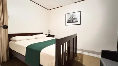 a bedroom with a bed with a green and white blanket at Apartamento San Juan in Santa Bárbaraa