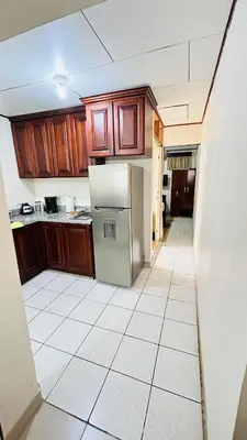 a kitchen with wooden cabinets and a refrigerator at Apartamento San Juan in Santa Bárbaraa