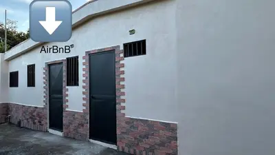 a white building with two doors and a sign on it at Apartamento San Juan in Santa Bárbaraa