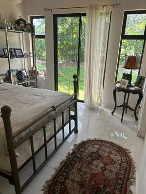 a bedroom with a bed and a large window at The House of Encantada in Liberia