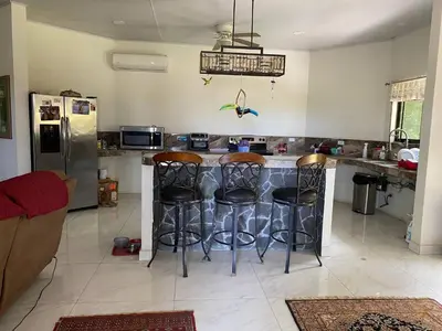 a kitchen with a bar with stools at The House of Encantada in Liberia