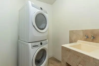 a washing machine in a bathroom next to a sink at Matapalo 202-Poolside Condo at Tamarindo in Tamarindo