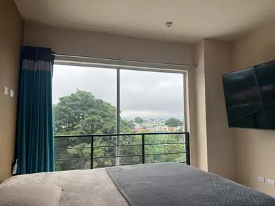 a bedroom with a large window with a view at Daitares Home in San Pedro