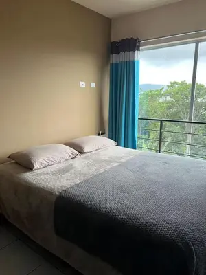 a bedroom with a bed and a large window at Daitares Home in San Pedro