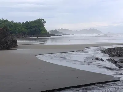 a beach with rocks and the ocean on a cloudy day at Casa Alma in Platanillo
