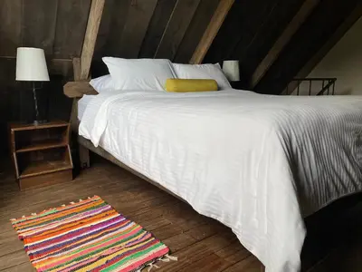 a bedroom with a white bed and a colorful rug at Villa Calas in Vara Blanca