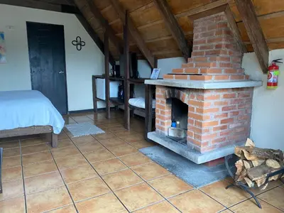 a brick fireplace in a room with a bed at Villa Calas in Vara Blanca