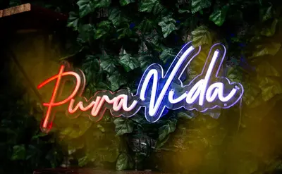 a neon sign that says funka village on a wall at Toscana Escazú in San Rafael