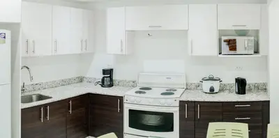a white kitchen with a stove and a sink at Toscana Escazú in San Rafael