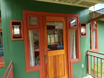 a green house with a wooden door and windows at Casa Hermosa FAM Little House in Santa María