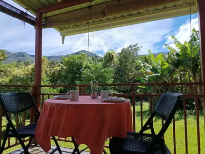 a table and chairs on a porch with a view at Casa Hermosa FAM Little House in Santa María