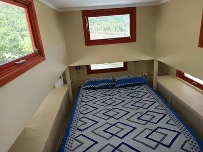 a small room with a bed and two windows at Casa Hermosa FAM Little House in Santa María