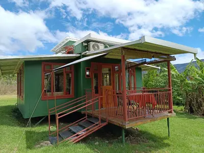 a green and red house with a porch at Casa Hermosa FAM Little House in Santa María