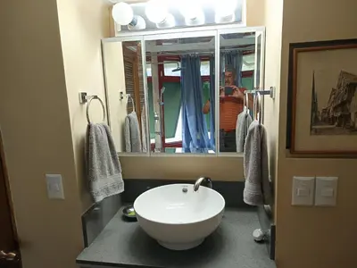 a woman taking a picture of a bathroom with a sink at Casa Hermosa FAM Little House in Santa María