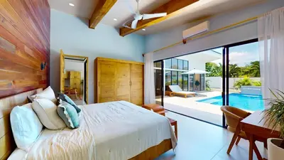 a bedroom with a large bed and a pool at Casa Luna Rosa in Uvita