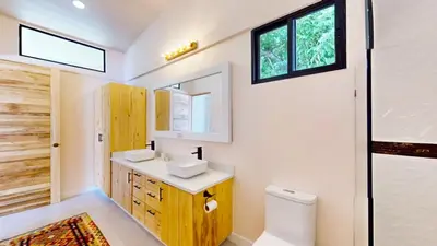 a bathroom with a sink and a toilet and a window at Casa Luna Rosa in Uvita