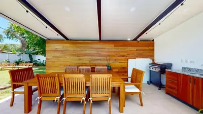 a dining room with a wooden table and chairs at Casa Luna Rosa in Uvita